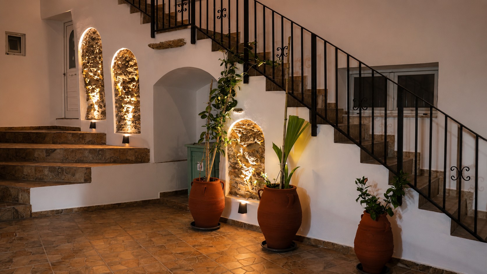 Η φωτισμένη αυλή της Aethra Seaview Suites το βράδυ